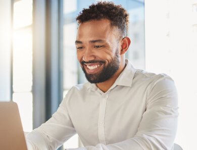 Imagem ilustrativa de homem feliz mexendo no laptop